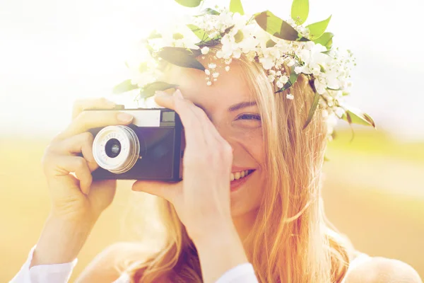 Femme heureuse avec caméra de film en couronne de fleurs — Photo