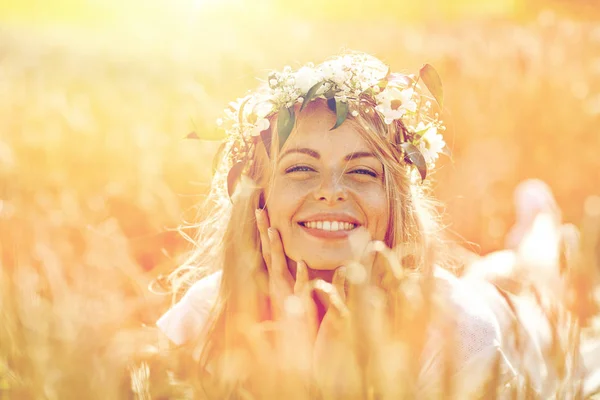 Šťastná žena v věnec květin na obilném poli — Stock fotografie