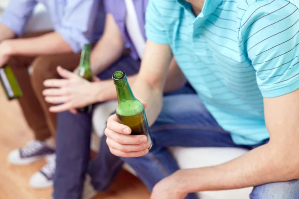 Hommes avec des bouteilles de bière assis sur le canapé à la maison — Photo