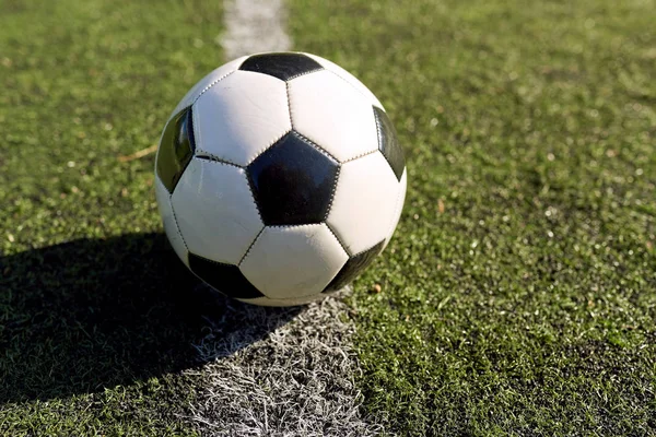 Футбольный мяч на линии разметки футбольного поля — стоковое фото