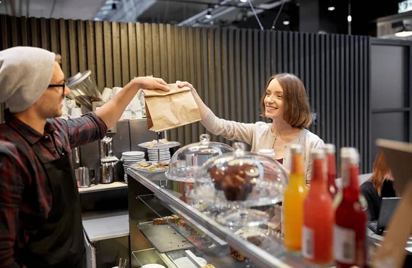 Mulher tomando saco de papel do vendedor no café — Fotografia de Stock