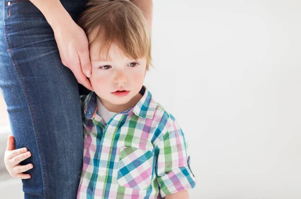 Trauriger kleiner Junge hält an Mutter fest — Stockfoto