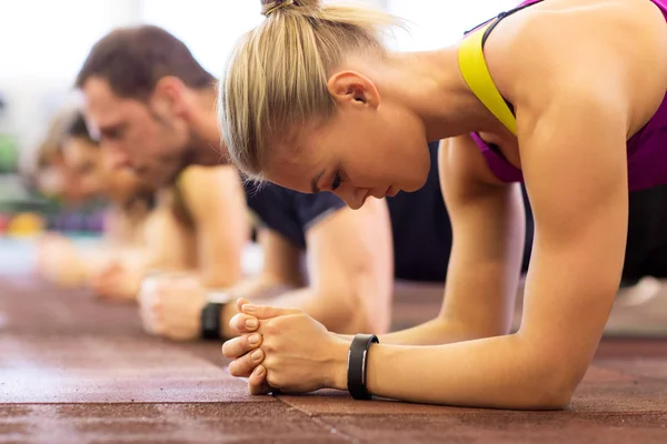 Detailní záběr z ženy na trénink dělá prkno v tělocvičně — Stock fotografie