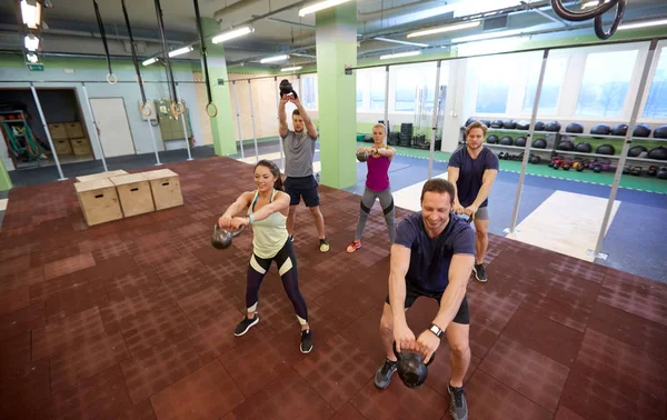 Gruppo di persone con kettlebells esercizio in palestra — Foto Stock