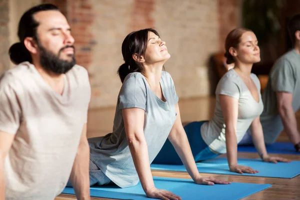 Groep mensen doen yoga hond pose in studio — Stockfoto