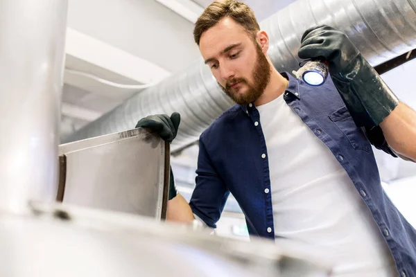 Hombre que trabaja en una fábrica de cerveza artesanal o una fábrica de cerveza —  Fotos de Stock