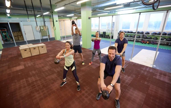 Ομάδα ανθρώπων με kettlebells άσκηση στο γυμναστήριο Εικόνα Αρχείου
