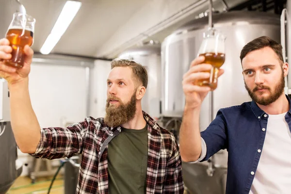 Muži pijící a testující řemeslné pivo v pivovaru — Stock fotografie