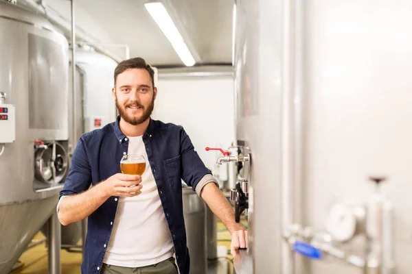 Человек пьет и испытывает ремесленное пиво на пивоварне — стоковое фото