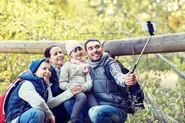 Lycklig familj med smartphone selfie pinne i skogen — Stockfoto