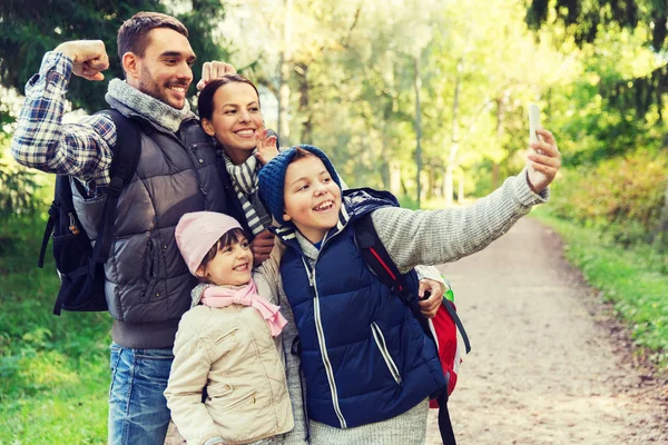 Family with backpacks taking selfie by smartphone — Stock Photo, Image