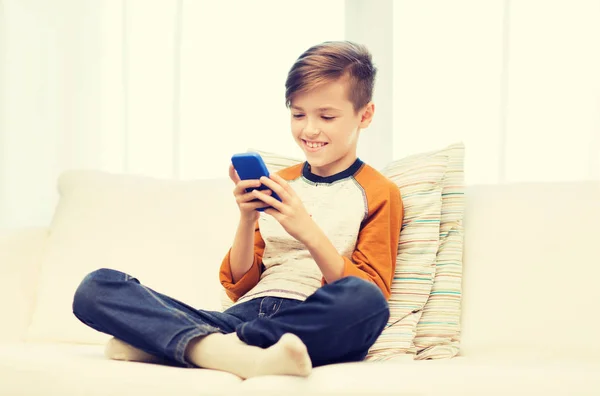 Boy with smartphone texting or playing at home — Stock Photo, Image