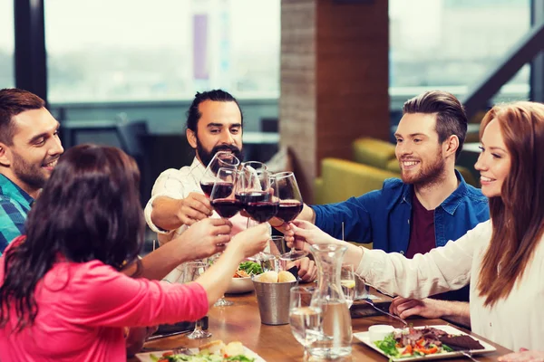 Přátelé stolování a pití vína v restauraci — Stock fotografie