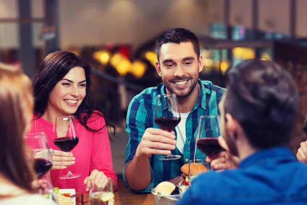 Amigos cenando y bebiendo vino en el restaurante —  Fotos de Stock