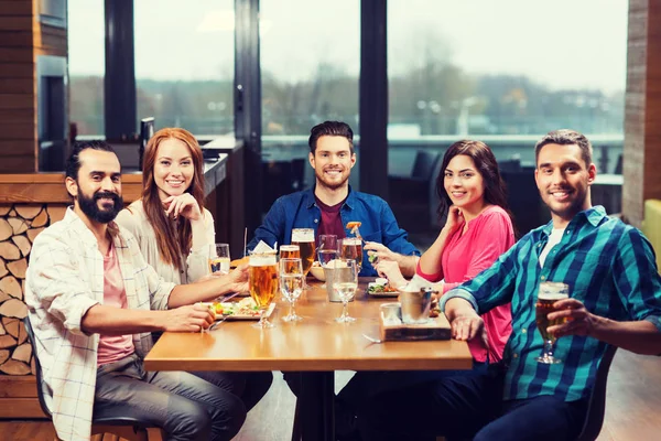 Друзья обедают и пьют пиво в ресторане — стоковое фото