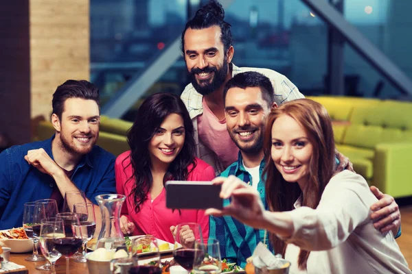 Amici che scattano selfie da smartphone al ristorante — Foto Stock