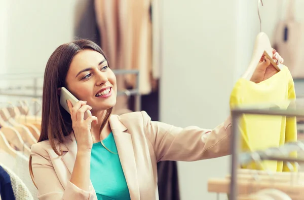 Kvinnan ringer på smartphone på klädaffär — Stockfoto