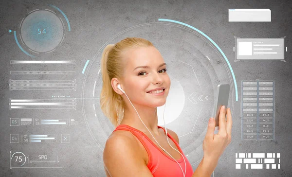 Mujer deportiva sonriente con teléfono inteligente y auriculares —  Fotos de Stock