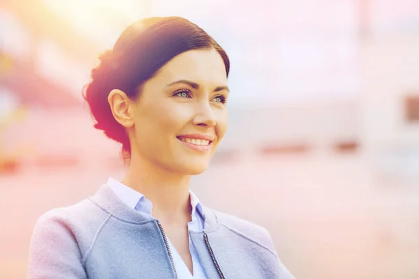 Молодая улыбающаяся деловая женщина над офисным зданием — стоковое фото