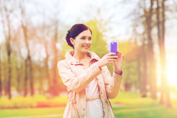 Усміхнена жінка фотографує зі смартфоном — стокове фото