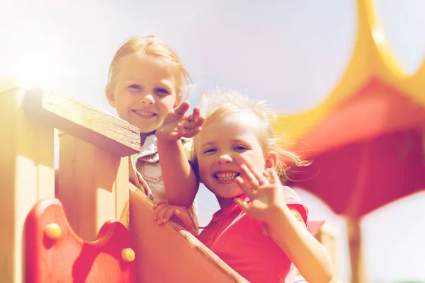 Meninas felizes acenando as mãos no parque infantil — Fotografia de Stock