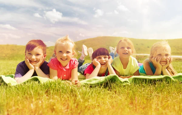 Gruppo di bambini sdraiati sulla coperta o al coperto all'aperto — Foto Stock