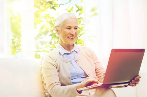 Mujer mayor feliz con el ordenador portátil en casa — Foto de Stock