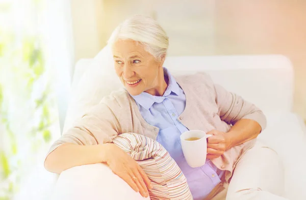 Feliz mujer mayor con taza de té en casa — Foto de Stock