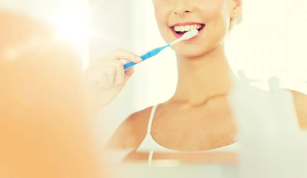 Donna con spazzolino da denti pulizia dei denti in bagno — Foto Stock