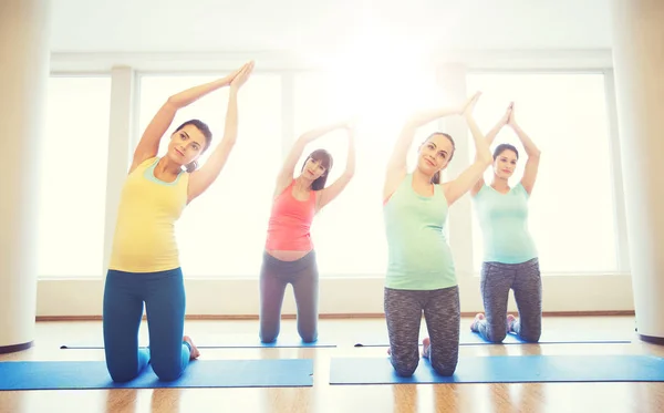 Felici donne incinte che esercitano su stuoie in palestra — Foto Stock