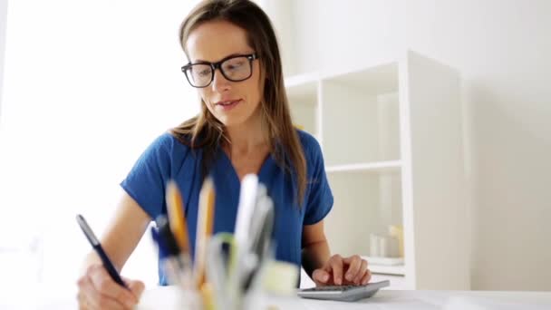 Vrouw met Rekenmachine en laptop op kantoor — Stockvideo