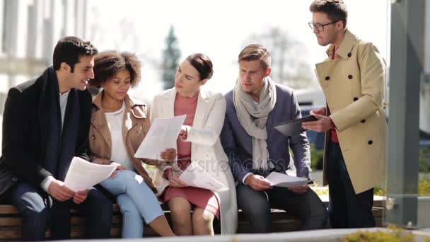 Equipo de negocios internacional con papeles al aire libre — Vídeos de Stock