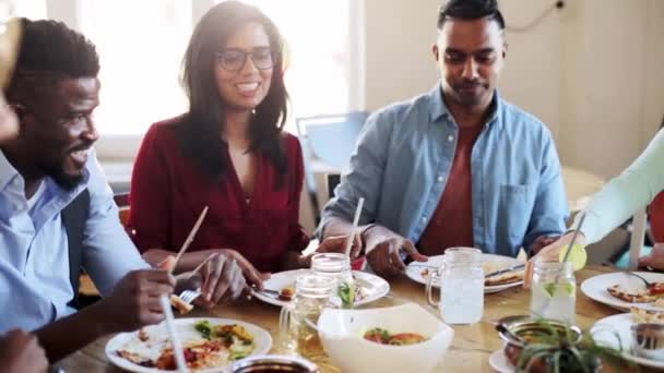 Друзья едят и звонят в стаканы в ресторане — стоковое видео