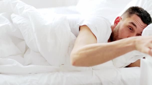 Hombre despertando y bebiendo agua en la cama en casa — Vídeos de Stock