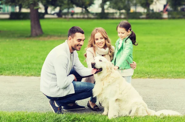 Lycklig familj med Labrador Retriever Dog i Park — Stockfoto