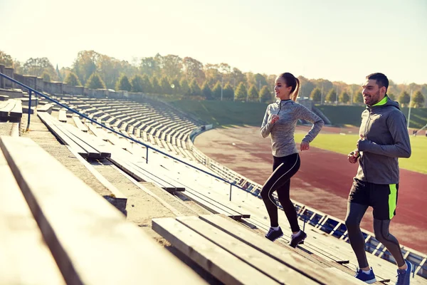 Feliz pareja corriendo arriba en el estadio — Foto de Stock