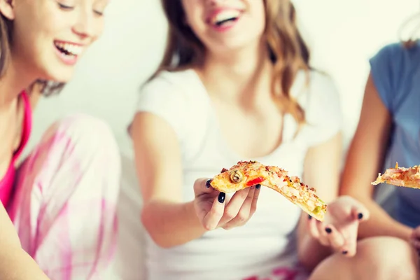 Щасливі друзі або дівчата-підлітки їдять піцу вдома — стокове фото