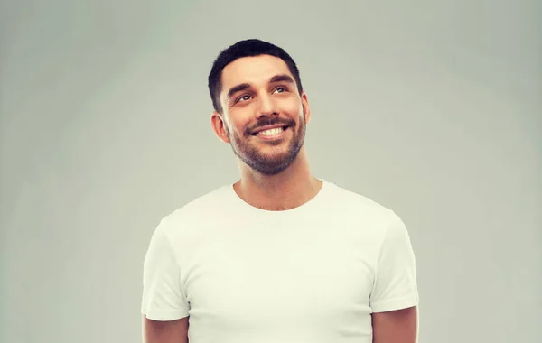 Uomo sorridente guardando su sfondo grigio — Foto Stock