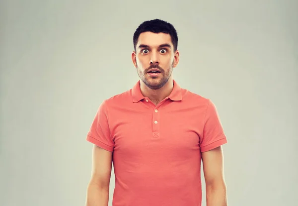 Hombre sorprendido en polo camiseta sobre fondo gris —  Fotos de Stock