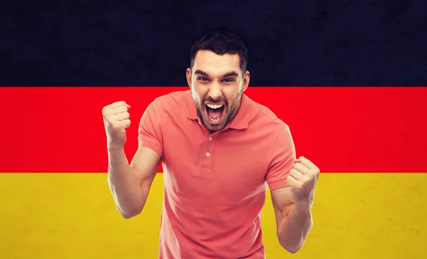 Hombre enojado mostrando puños sobre bandera alemana Fotos De Stock Sin Royalties Gratis