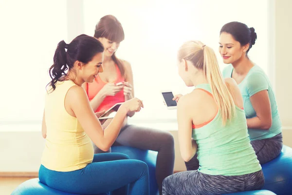 Mujeres embarazadas felices con gadgets en el gimnasio —  Fotos de Stock