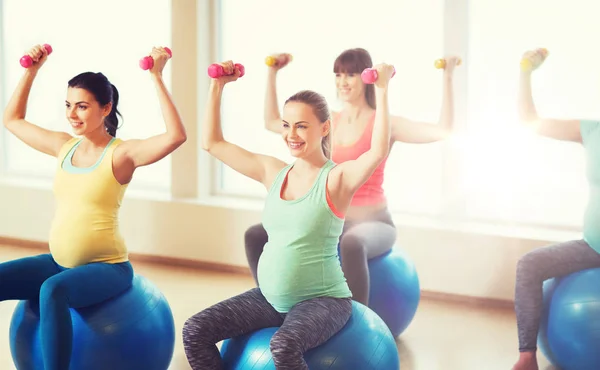 Glada gravida kvinnor utövar på fitball i gym — Stockfoto