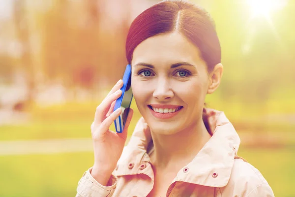 Lachende vrouw bellen op smartphone in park — Stockfoto