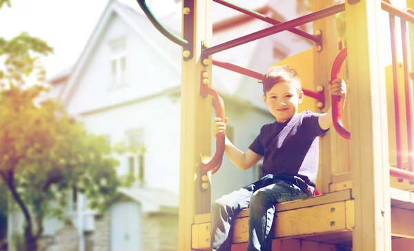 Lycklig pojke på lekplats klättring ram — Stockfoto