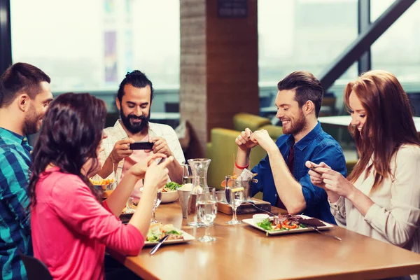 Amici felici scattare foto di cibo al ristorante — Foto Stock