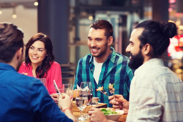 Gelukkige vrienden met diner in restaurant — Stockfoto