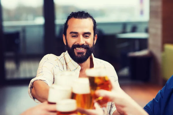 Muž cinkání pivní sklo s přáteli v restauraci — Stock fotografie