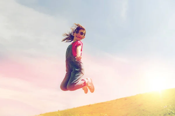 Happy little girl jumping high outdoors — Stock Photo, Image