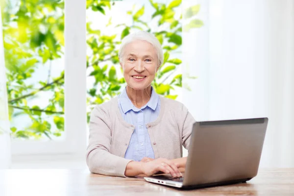 Mulher sênior feliz com laptop em casa — Fotografia de Stock