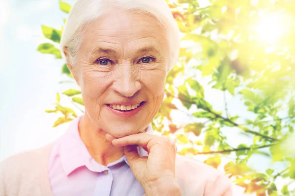 Счастливая пожилая женщина на зеленом природном фоне — стоковое фото